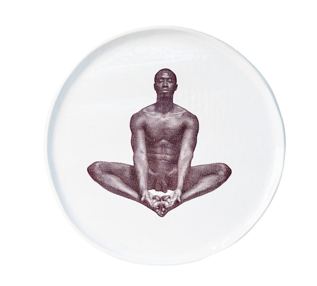 Brown oxide transfer of a seated figure with soles together on stoneware Gestures plate, J Schatz.