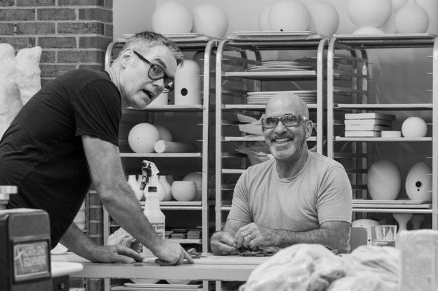 Jim Schatz and Peter Souza Jr. in their Detroit studio with shelves of unfinished ceramic forms