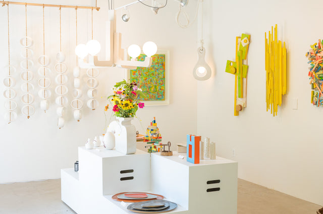 Surface installation at Take Me Home — White Orb Sculpture, Four Arm Chandelier, and Aura Pendant Lamp by Jim Schatz with painted wood wall works by Peter Souza Jr.