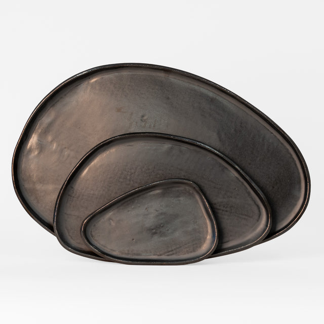 Black Amorphous Platter Set — three hand-formed speckled stoneware platters in a hand-glazed black finish, handmade in Detroit by J Schatz.