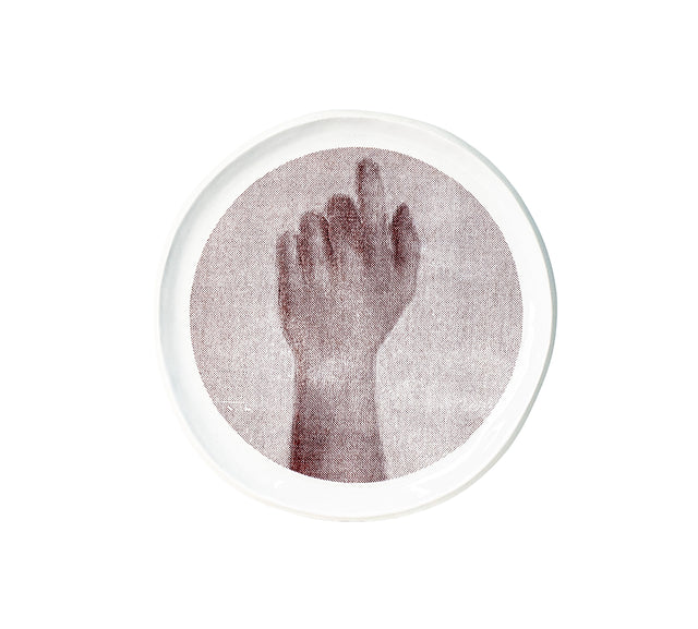 Brown oxide transfer of a raised forearm and curled hand on stoneware Gestures plate, J Schatz.