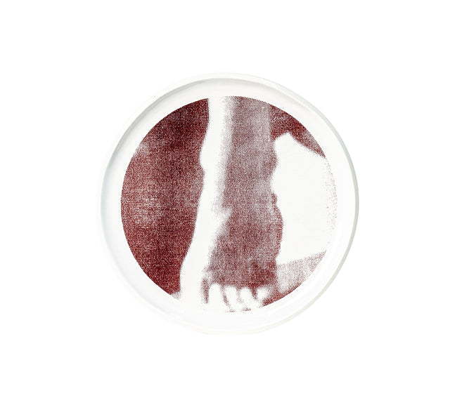 Brown oxide transfer of a forearm pressed against the body on stoneware Gestures plate, J Schatz.