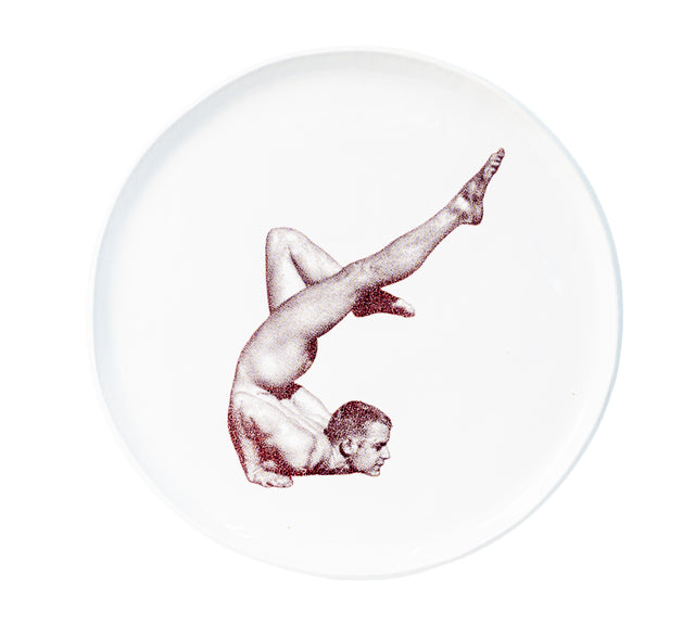 Brown oxide transfer of a shoulder stand with one leg extended on stoneware Gestures plate, J Schatz.