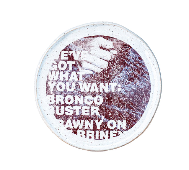 Brown oxide transfer of Honcho cover text beside a clenched fist on speckled stoneware plate, J Schatz and Peter Souza Jr.