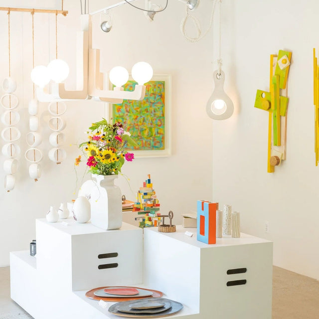 Surface installation at Take Me Home — ceramic lighting and vessels by Jim Schatz with painted wood wall works by Peter Souza Jr.