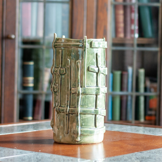 Green-glazed ceramic vessel styled on a table, J Schatz